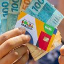 Dinheiro e cart&atilde;o do Bolsa Fam&iacute;lia.