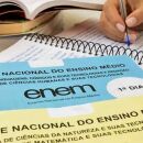 Pessoa estudando com caderno do Enem de lado.
