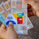 Pessoa segurando cart&atilde;o do Bolsa Fam&iacute;lia e benef&iacute;cio.