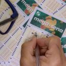 Pessoa marcando cartela da Mega-Sena.