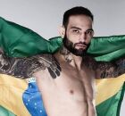 A imagem ilustra o lutador Guilherme Bomba segurando a bandeira do Brasil.