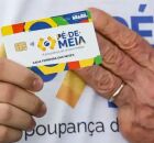 Cart&atilde;o do Bolsa Fam&iacute;lia e m&atilde;o de Lula.