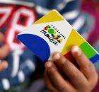 Pessoa segurando cart&atilde;o do Bolsa Fam&iacute;lia. 