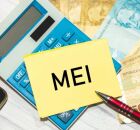 Calculadora, dinheiro e papel escrito MEI.