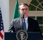 Jair Bolsonaro ao lado da bandeira dos Estados Unidos.