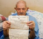 Jos&eacute; Jer&ocirc;nimo Gomes, Seu Caju, de 117 anos segurando certid&atilde;o de nascimento.