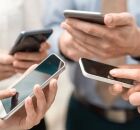 Pessoas mexendo no celular.