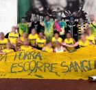 Alunos de faculdade em evento esportivo com faixa.