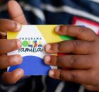 Crian&ccedil;a segurando cart&atilde;o do Bolsa Fam&iacute;lia.