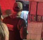 Policial em frente &agrave; casa onde trio foi assassinado.