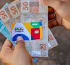 Pessoa segurando cart&atilde;o do Bolsa Fam&iacute;lia e benef&iacute;cio.