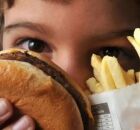 Crian&ccedil;a segurando fastfood