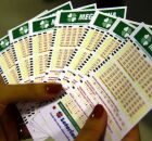 Mulher segurando tal&otilde;es da Mega-Sena.