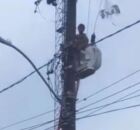 Menino tentando resgatar pipa em poste, no Recife.