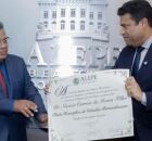 Joel da Harpa entregando t&iacute;tulo ao pastor na Alepe.