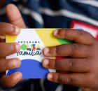 Crian&ccedil;a segurando cart&atilde;o do Bolsa Fam&iacute;lia.