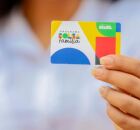 Mulher segurando cart&atilde;o do Bolsa Fam&iacute;lia.