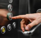 Pessoa apertando bot&otilde;es de elevador. 