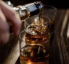 Pessoa colocando bebida alco&oacute;lica em copos.