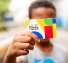 Menino segurando cart&atilde;o do Bolsa Fam&iacute;lia.