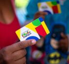 Mulher e crian&ccedil;as segurando cart&otilde;es do Bolsa Fam&iacute;lia.