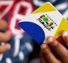 Crian&ccedil;a segurando cart&atilde;o do Bolsa Fam&iacute;lia.