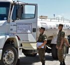 Carro-pipa do Ex&eacute;rcito e soldados ao lado.