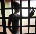 Pessoa com m&atilde;o em porta de vidro.