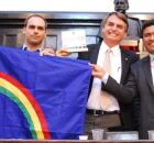 Deputado Joel da Harpa ao lado de Bolsonaro e Eduardo, segurando bandeira de Pernambuco.
