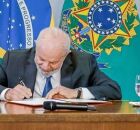 Lula assinando documento.