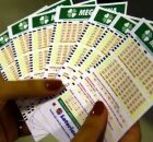 Mulher segurando cartelas da Mega-Sena.