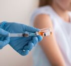 Profissional de sa&uacute;de aplica vacina em crian&ccedil;a para prevenir meningite, principal medida de prote&ccedil;&atilde;o.