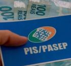 Pessoa segurando cart&atilde;o do PIS/Pasep e dinheiro do abono salarial.