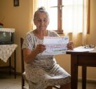 Idoso segurando uma conta de energia. 