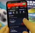 Pessoa mexendo em aplicativo de apostas no celular.