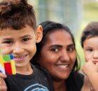 M&atilde;e com seus dois filhos, segurando cart&atilde;o do Bolsa Fam&iacute;lia.