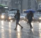 Pessoas na rua em dia de chuva.