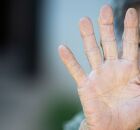 Pessoa idosa estendendo a m&atilde;o.