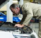 Homem confere o motor do carro durante revis&atilde;o antes de viagem de fim de ano.