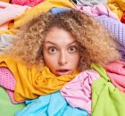 Mulher analisa diferentes pe&ccedil;as coloridas enquanto escolhe o tom ideal para usar na virada do ano.