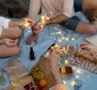 Pessoas celebrando a virada de ano com simpatias tradicionais, entre uvas, roupas brancas, em busca de boas energias.