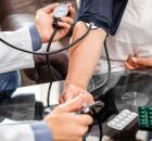 Profissional de sa&uacute;de acompanha a press&atilde;o arterial de um paciente para refor&ccedil;ar a preven&ccedil;&atilde;o do AVC.