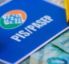 Cart&atilde;o do PIS/Pasep com dinheiro em volta.