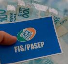 Pessoa segurando cart&atilde;o do PIS/Pasep com dinheiro do abono.