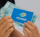 Pessoa com cart&atilde;o do PIS/Pasep e dinheiro do abono.