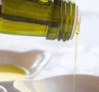 Garrafa com azeite de oliva sendo derramado.