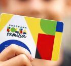 Crian&ccedil;a segurando cart&atilde;o do Bolsa Fam&iacute;lia. 