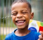 Crian&ccedil;a segurando cart&atilde;o do Bolsa Fam&iacute;lia.