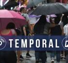 Pessoas se abrigando das precipita&ccedil;&otilde;es com guarda-chuvas.