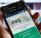 Pessoa mexendo no aplicativo do Fies.